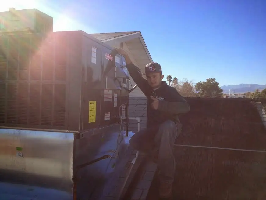 HVAC technician performing Air Duct Repair on a rooftop unit in Bradfordville